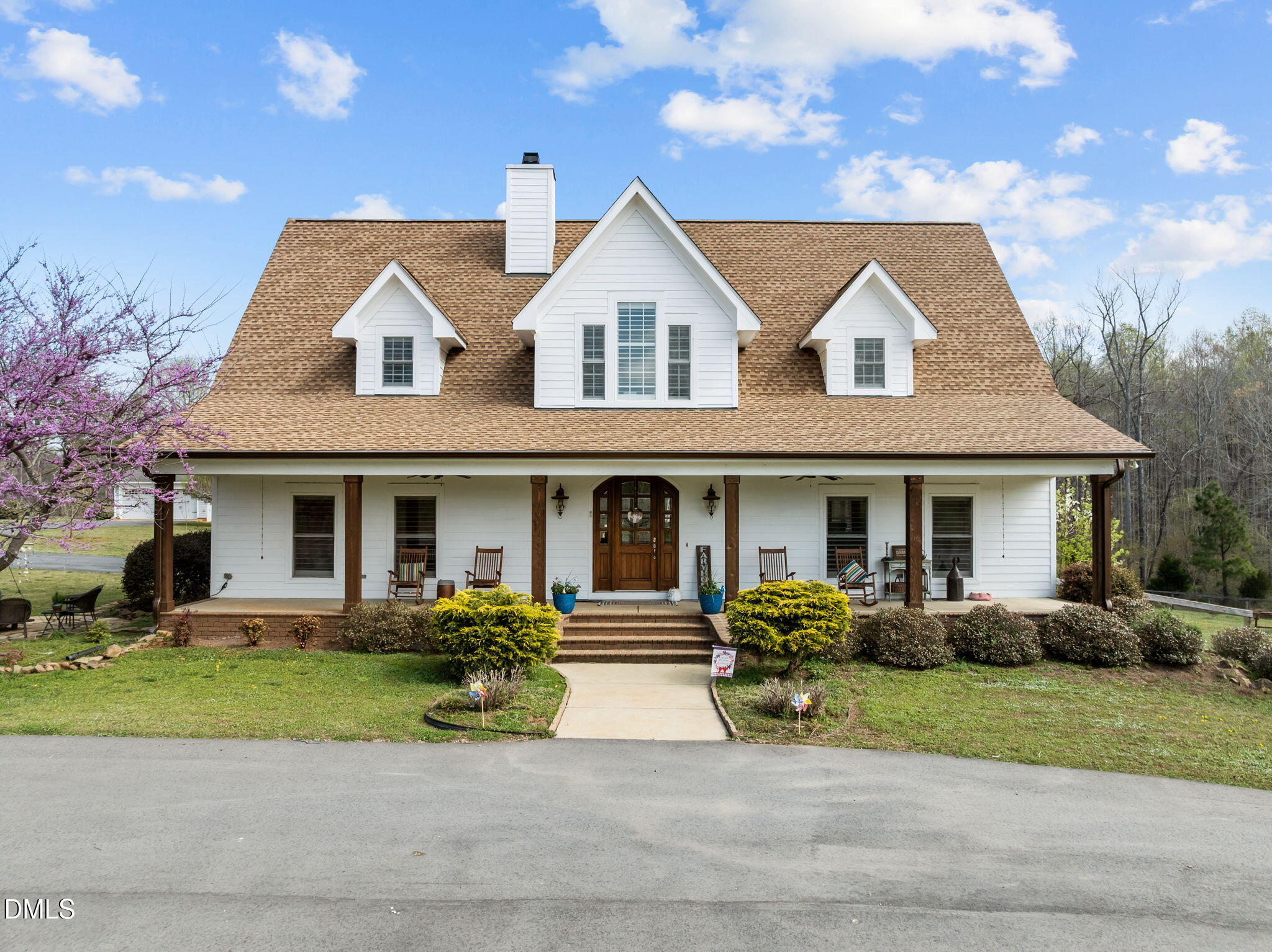 a front view of a house with garage and plants