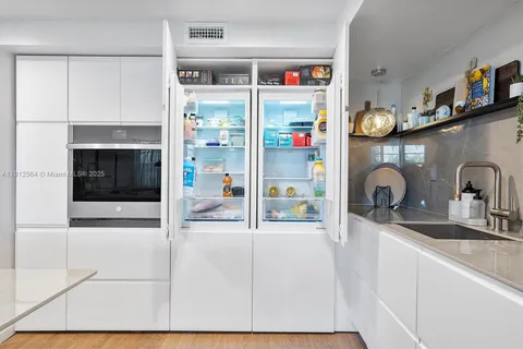 a kitchen with stainless steel appliances granite countertop a sink and a refrigerator