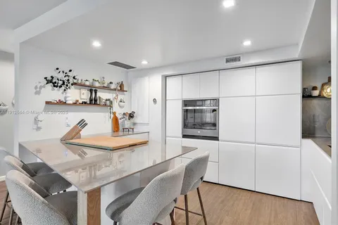 a kitchen with a table chairs refrigerator and microwave