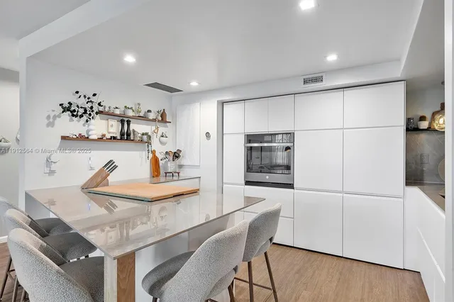a kitchen with a table chairs refrigerator and microwave