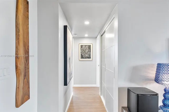 a kitchen with granite countertop a sink stove and white cabinets with wooden floor