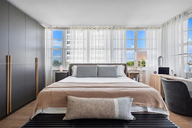 a bedroom with a bed and a potted plant on the dresser
