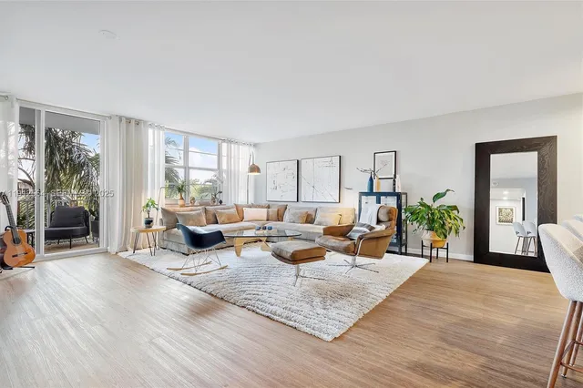 a living room with furniture floor to ceiling window and wooden floor