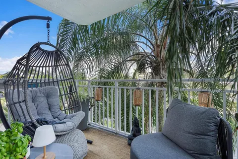 a view of a porch with chairs and potted plants