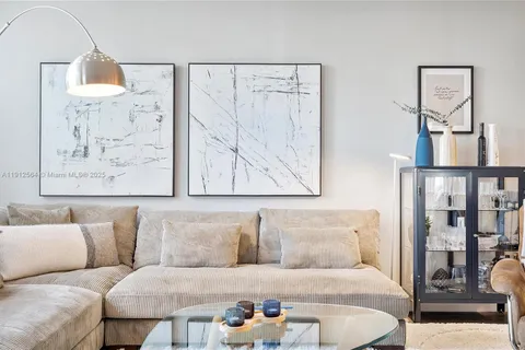 a living room with furniture and a painting on the wall