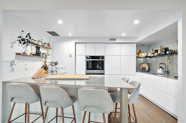 a kitchen with stainless steel appliances granite countertop a sink and a refrigerator