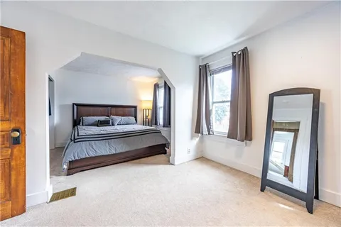 a bedroom with a bed and a large window