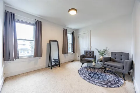 a living room with furniture chess and a window