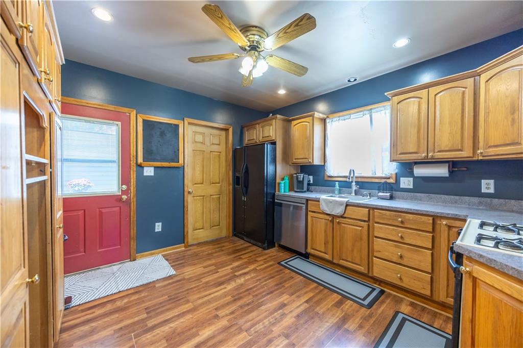 201 Walters Lane Springdale, PA 15144 - Photo 5 of 24 a kitchen with stainless steel appliances granite countertop a refrigerator a sink dishwasher a stove and white countertops with wooden floor