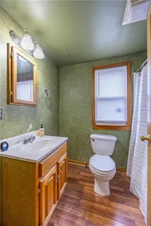 a bathroom with a granite countertop toilet sink and mirror