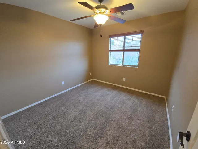 an empty room with a window and a ceiling fan