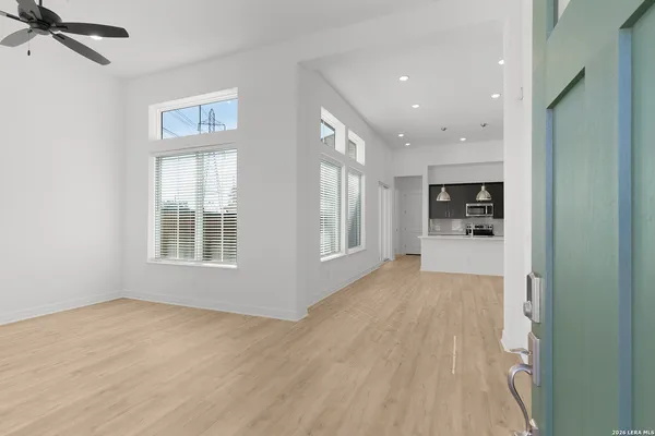 a view of empty room with wooden floor and window
