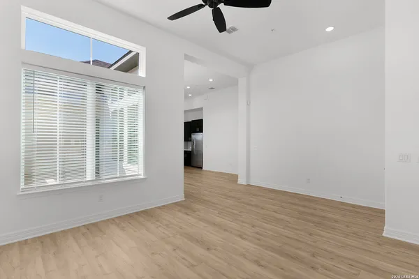 a view of an empty room with a window and wooden floor
