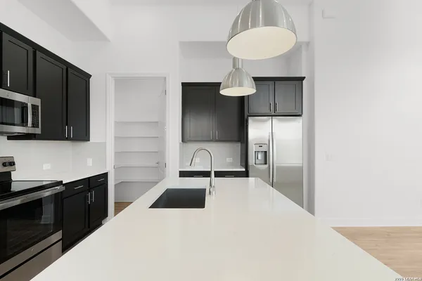 a kitchen with stainless steel appliances a sink stove and refrigerator