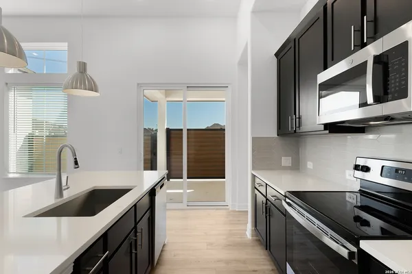 a kitchen with stainless steel appliances a sink stove and microwave
