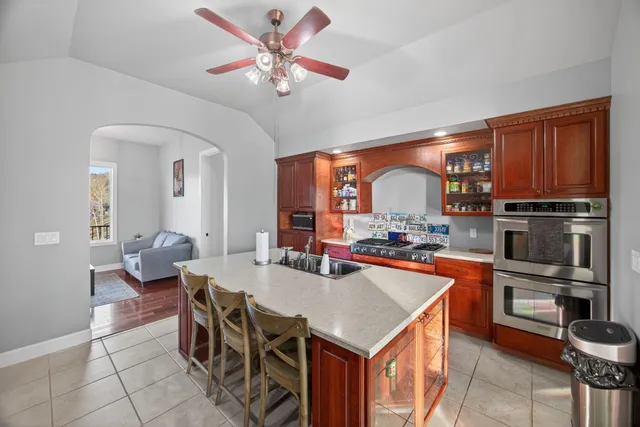 a kitchen with stainless steel appliances granite countertop a sink dishwasher and a refrigerator with wooden cabinets