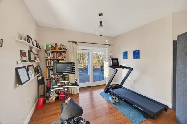 a front view of a house with lots of trees and plants