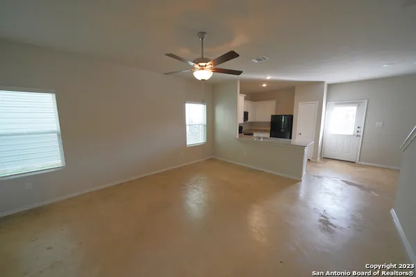 a view of a livingroom with a ceiling fan window and wooden floor