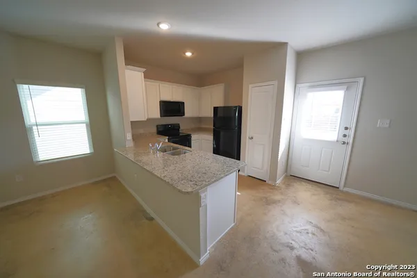 a kitchen with kitchen island granite countertop cabinets and refrigerator
