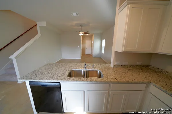 a kitchen with granite countertop a sink and cabinets