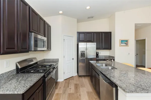 a kitchen with granite countertop stainless steel appliances and wooden cabinets