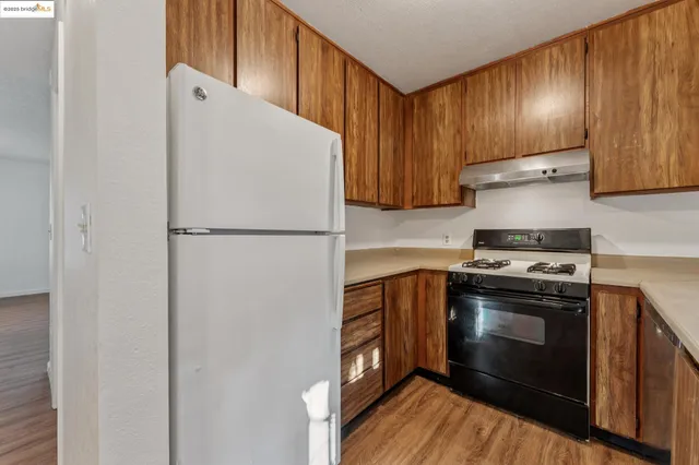 a kitchen with a stove a refrigerator and a sink