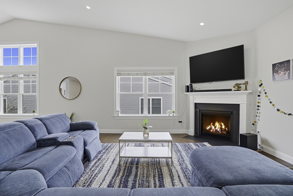 52 Logans Run, Unit 52 Millbury, MA 01527 - Photo 19 of 41 a living room with furniture a fireplace and a flat screen tv