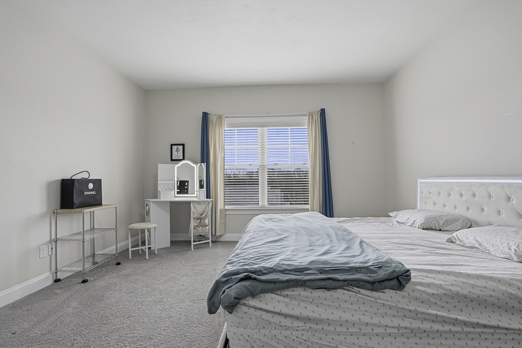 52 Logans Run, Unit 52 Millbury, MA 01527 - Photo 25 of 41 a spacious bedroom with a bed and glass table
