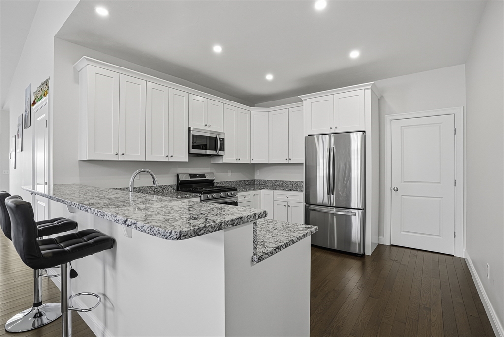 52 Logans Run, Unit 52 Millbury, MA 01527 - Photo 3 of 41 a kitchen with stainless steel appliances granite countertop a refrigerator sink and cabinets
