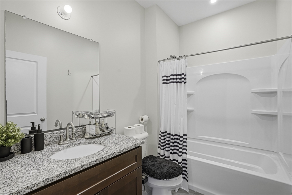 52 Logans Run, Unit 52 Millbury, MA 01527 - Photo 31 of 41 a bathroom with a granite countertop sink a toilet and shower