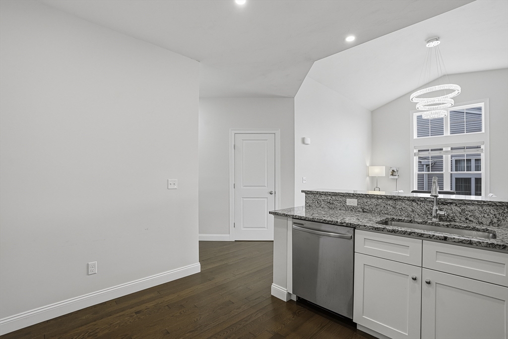 52 Logans Run, Unit 52 Millbury, MA 01527 - Photo 9 of 41 a hallway with granite countertop white cabinets and wooden floor