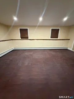 an empty room with wooden floor and white walls