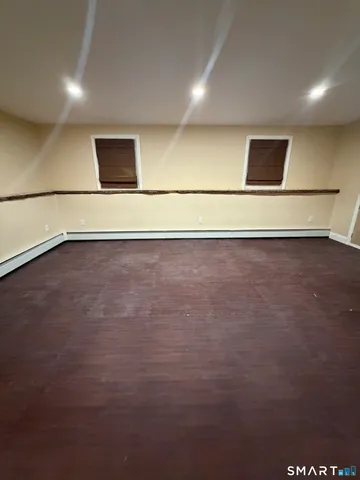 an empty room with wooden floor and white walls