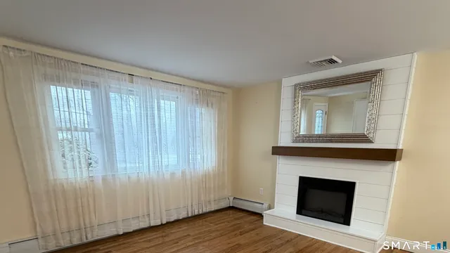 a living room with a fireplace and a wooden floor