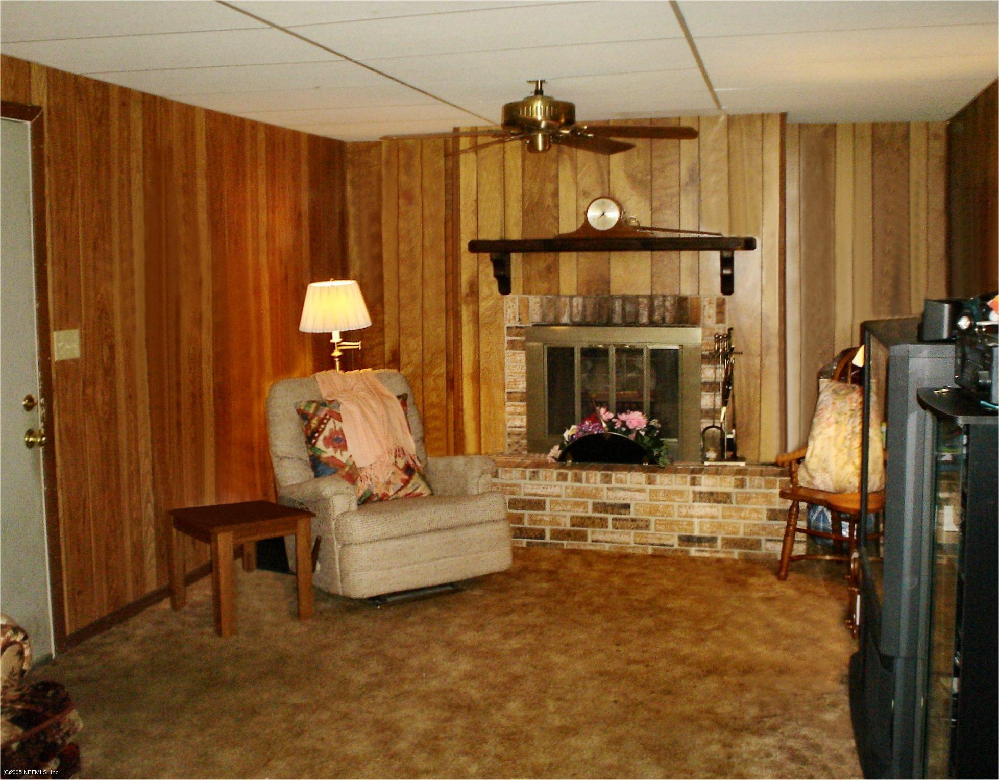 4043 Rogero Road Jacksonville, FL 32277 - Photo 3 of 6 a living room with furniture a fireplace and a flat screen tv