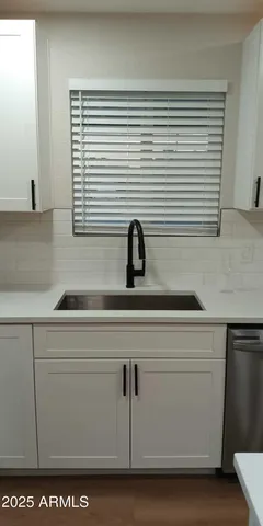 a kitchen with a sink and wooden floor
