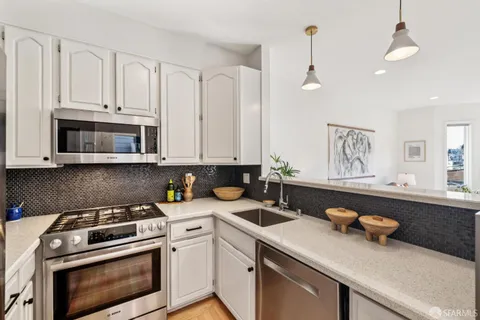 a kitchen with cabinets appliances a sink and a counter top space