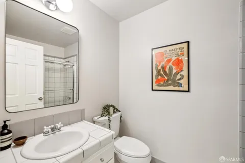 a bathroom with a toilet a sink and mirror