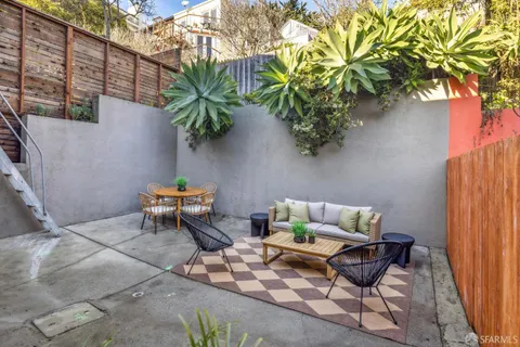 a white bench sitting in backside of a house with potted plants