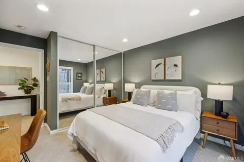 a bedroom with bed and a view of living room