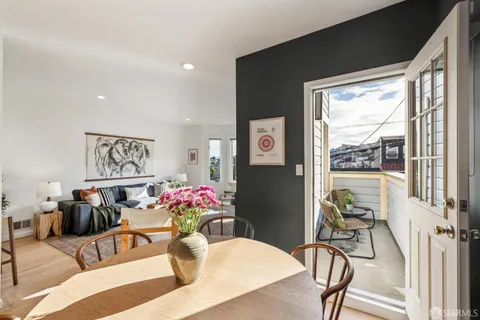 a living room with furniture potted plant and floor to ceiling windows