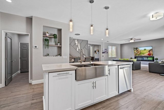 a bedroom with a large bed and a chandelier fan