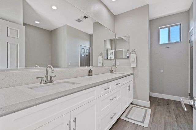 a bathroom with a tub and wooden floor