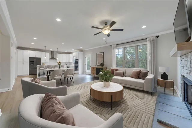 a living room with furniture kitchen view and a large window