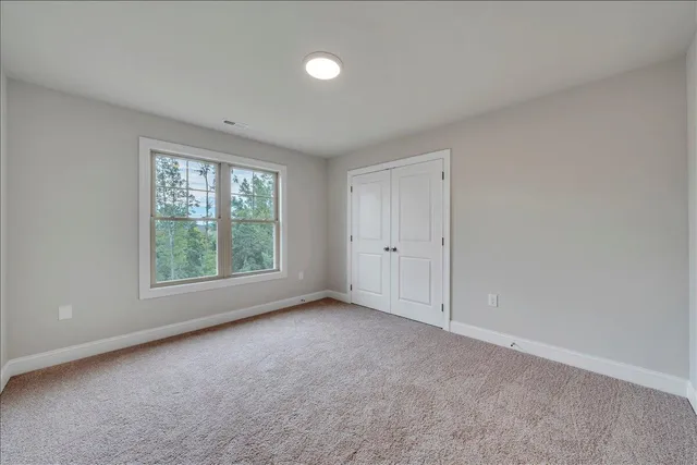 an empty room with windows and closet