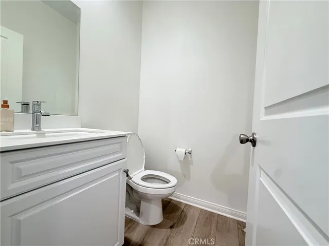 an empty room with a wooden floor and windows