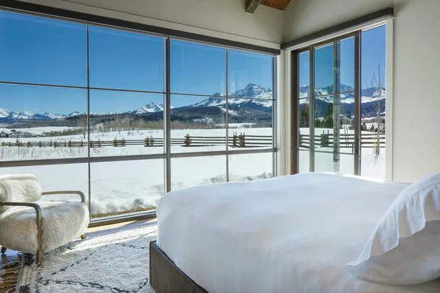a bedroom with a bed and large window