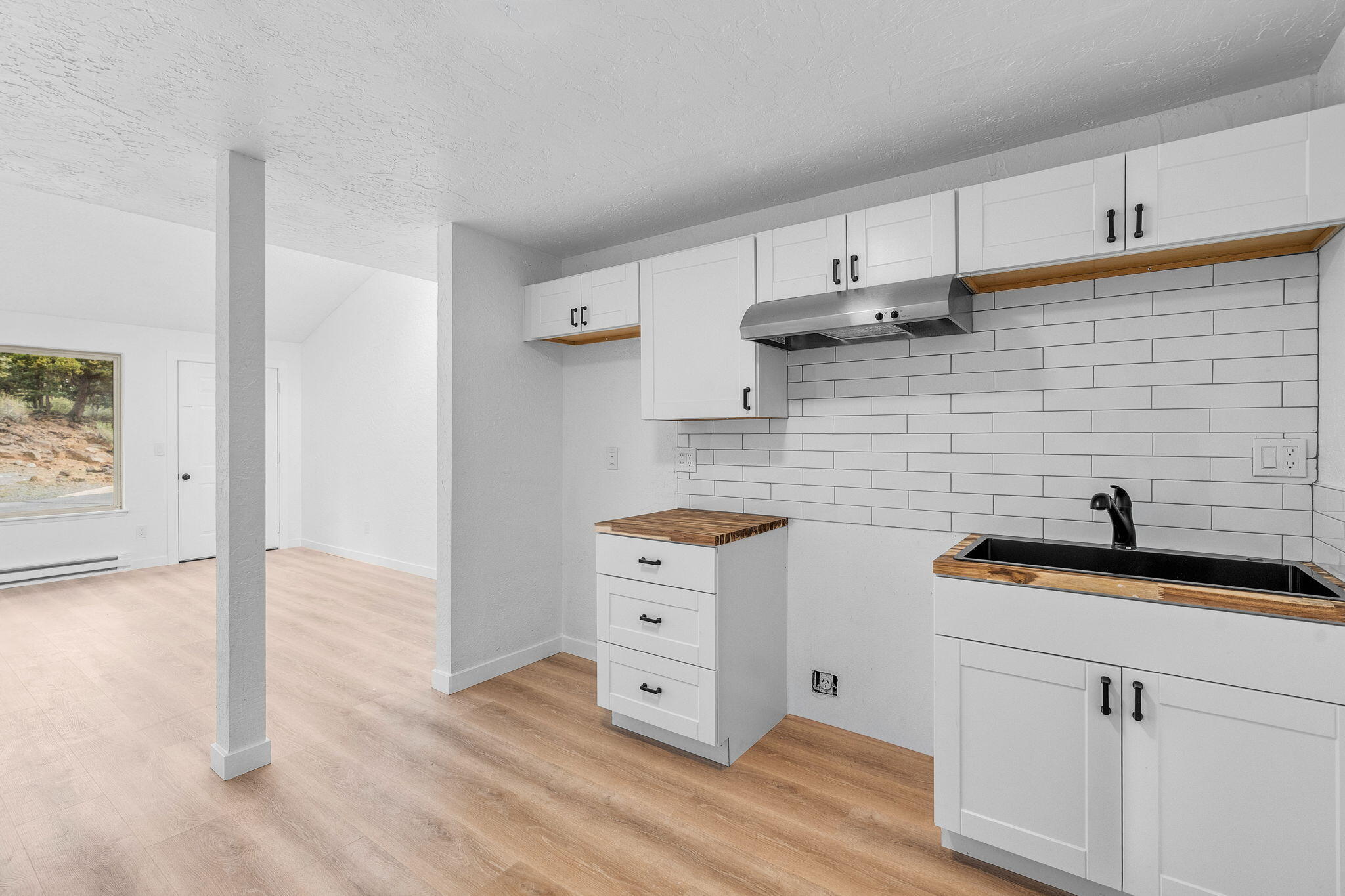 1700 Northeast Wells Acres Road, Unit 25 Bend, OR 97701 - Photo 14 of 25 a kitchen with stainless steel appliances white cabinets and wooden floor
