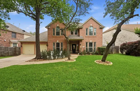 a front view of a house with a yard and trees