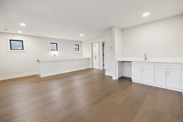 a view of a kitchen with wooden floor and a sink